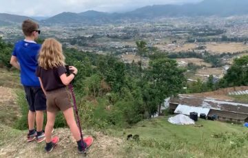 Nagarkot hiking trail with hikers overlooking the Langtang Dorje Lakpa and Langtang Himalayan range in Nepal