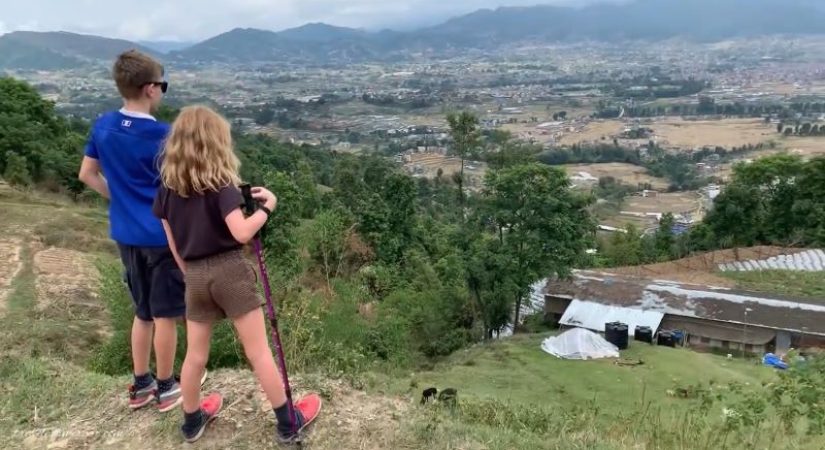 Nagarkot hiking trail with hikers overlooking the Langtang Dorje Lakpa and Langtang Himalayan range in Nepal