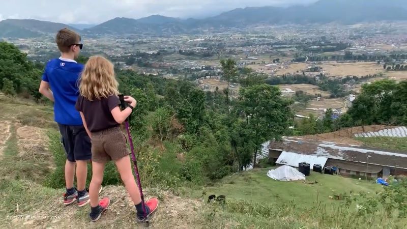 Nagarkot hiking trail with hikers overlooking the Langtang Dorje Lakpa and Langtang Himalayan range in Nepal