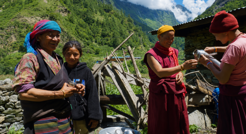 Traditional mountain village scene with local people and trekkers in the Himalayas